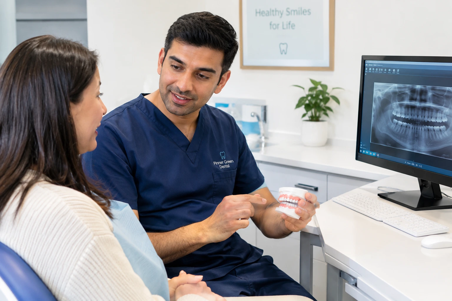 Dentist explaining the dental implant treatment timeline to a patient at Pinner Green Dental